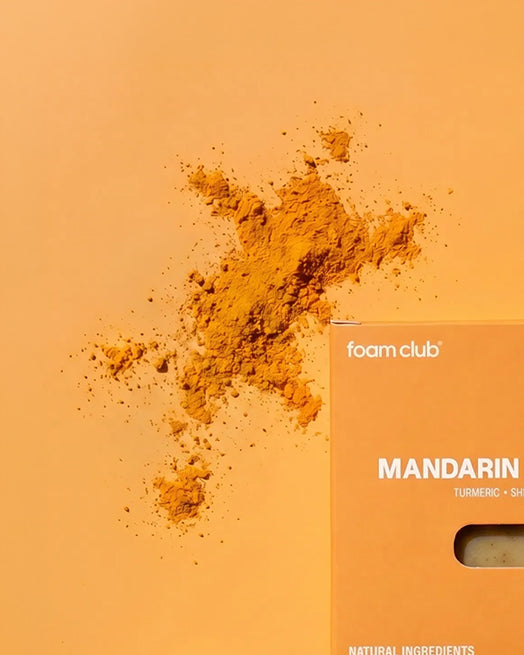turmeric powder next to turmeric soap with orange background